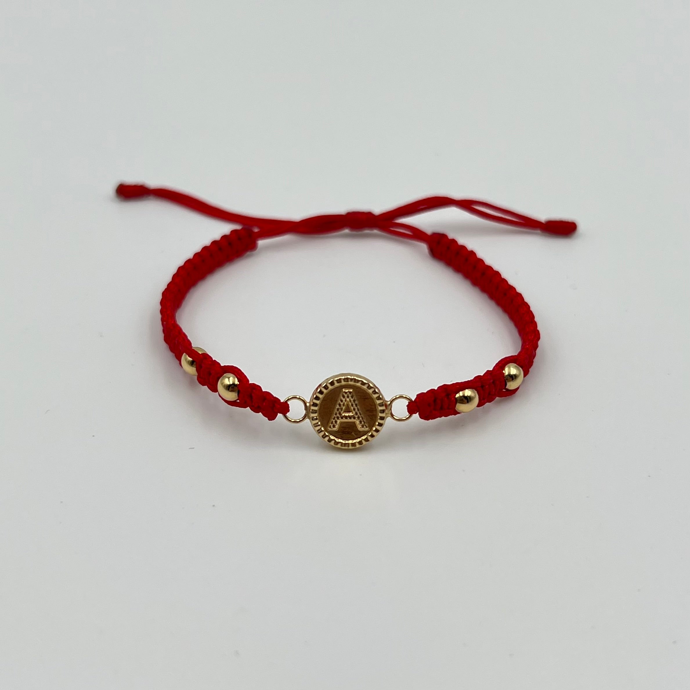 PULSERA TEJIDA ROJA / HERRAJE LETRA A / BOLA LISA 4MM