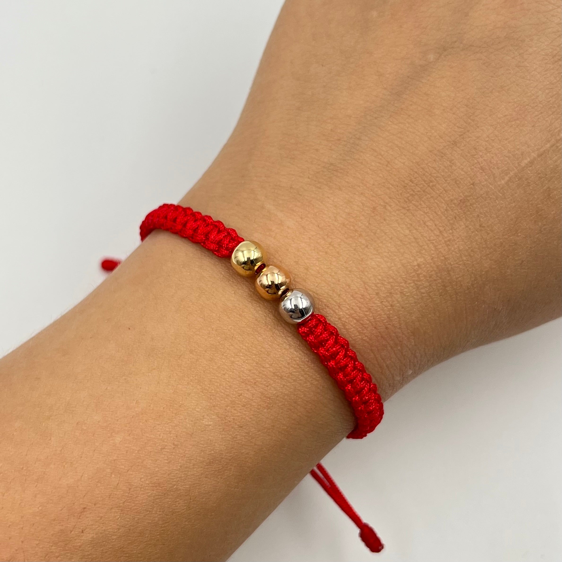 PULSERA TEJIDA ROJA / TRES OROS / BOLA LISA 6MM